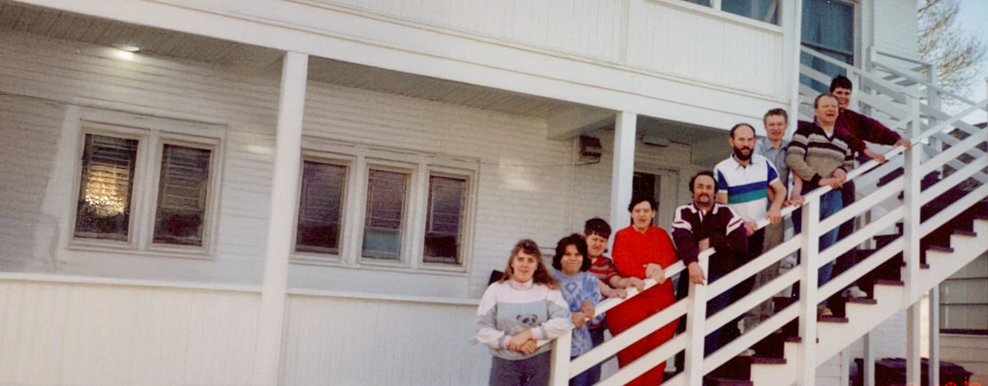 A group photo of the individuals who founded AWARE, standing on an outdoor staircase in front of a white building.
